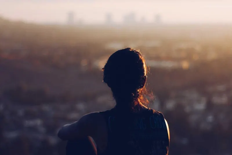 Mulher olhando a cidade no fim de tarde